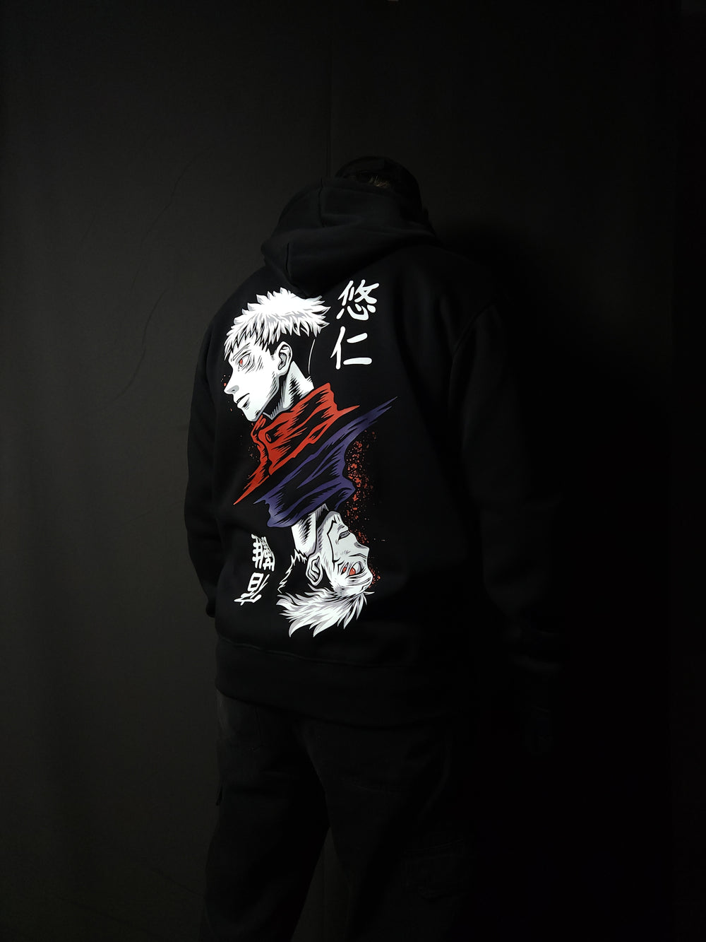 Anime-inspired apparel featuring bold back artwork, worn by a model in a dark studio setting – from a South African anime clothing brand.