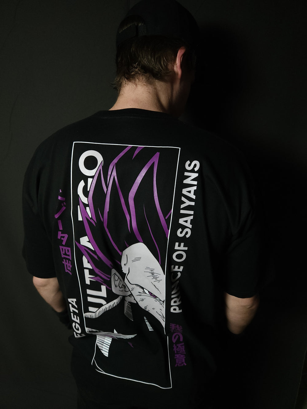 Anime-inspired apparel featuring bold back artwork, worn by a model in a dark studio setting – from a South African anime clothing brand.