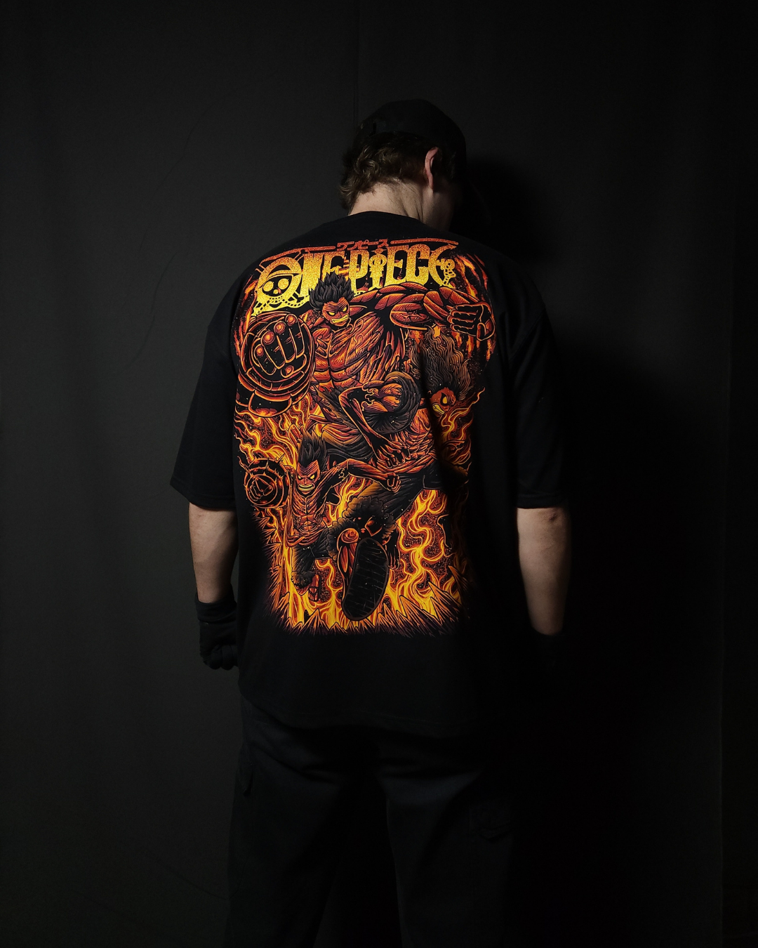 Anime-inspired apparel featuring bold back artwork, worn by a model in a dark studio setting – from a South African anime clothing brand.